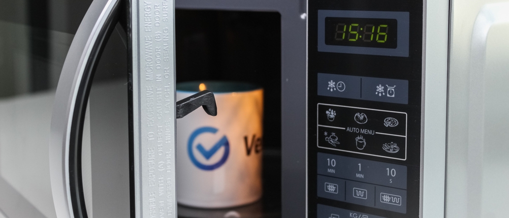 Offene Mikrowelle mit Display, das die Uhrzeit anzeigt, wird getestet