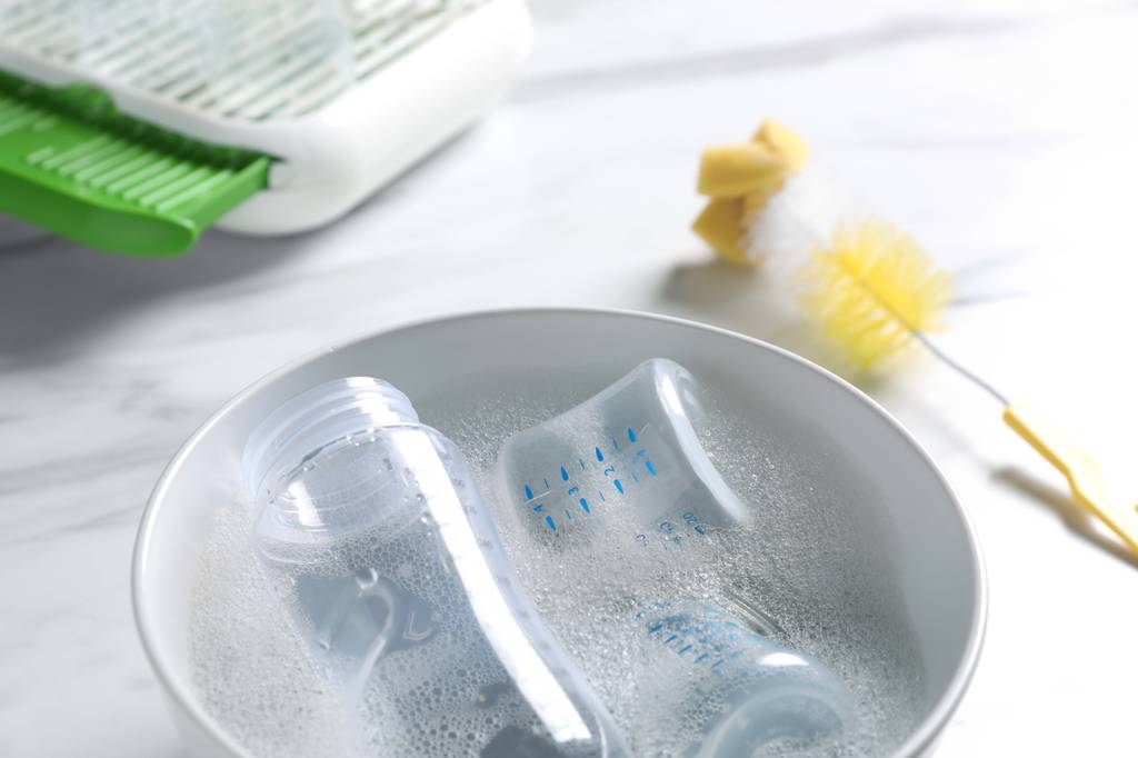 Mikrowellen-Sterilisator-Test: Babyflaschen befinden sich in der kleinen Keramik-Schale mit Wasser und Spülmittel. 