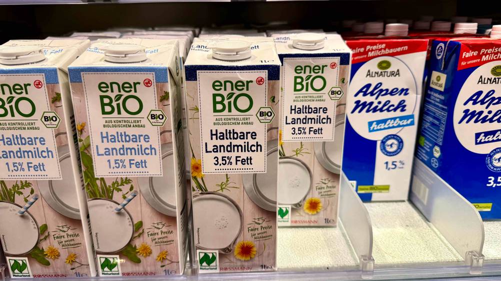 Mehrere Packungen Milch im Test stehen in einem Verkaufsregal.