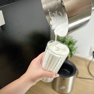 Milchschaum wird aus dem WMF Lono Milk & Choc in ein Glas gegossen. Der Auslauf ermöglicht präzises Eingießen ohne Tropfen.