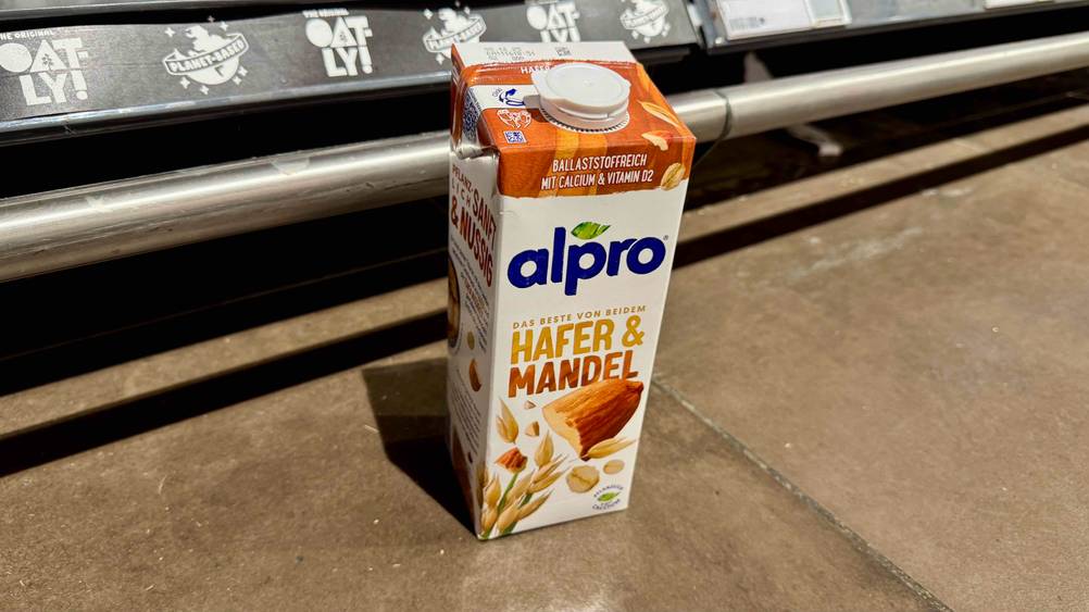 Vor einem Regal auf dem Boden steht eine Packung des Milchersatzes auf dem Boden.
