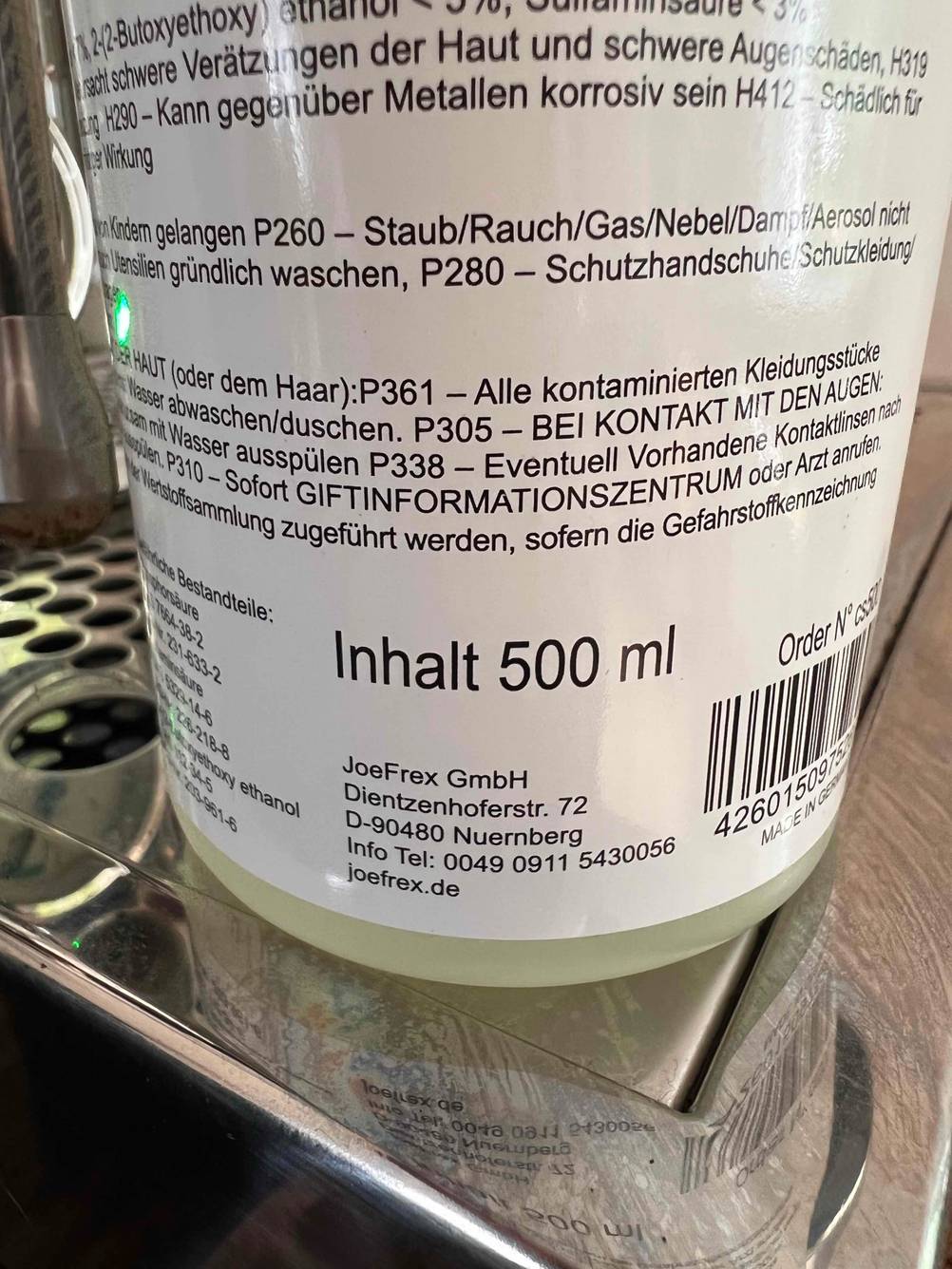 Nahaufnahme des Aufdrucks auf der Rückseite einer Flasche Milchsystemreiniger im Test.