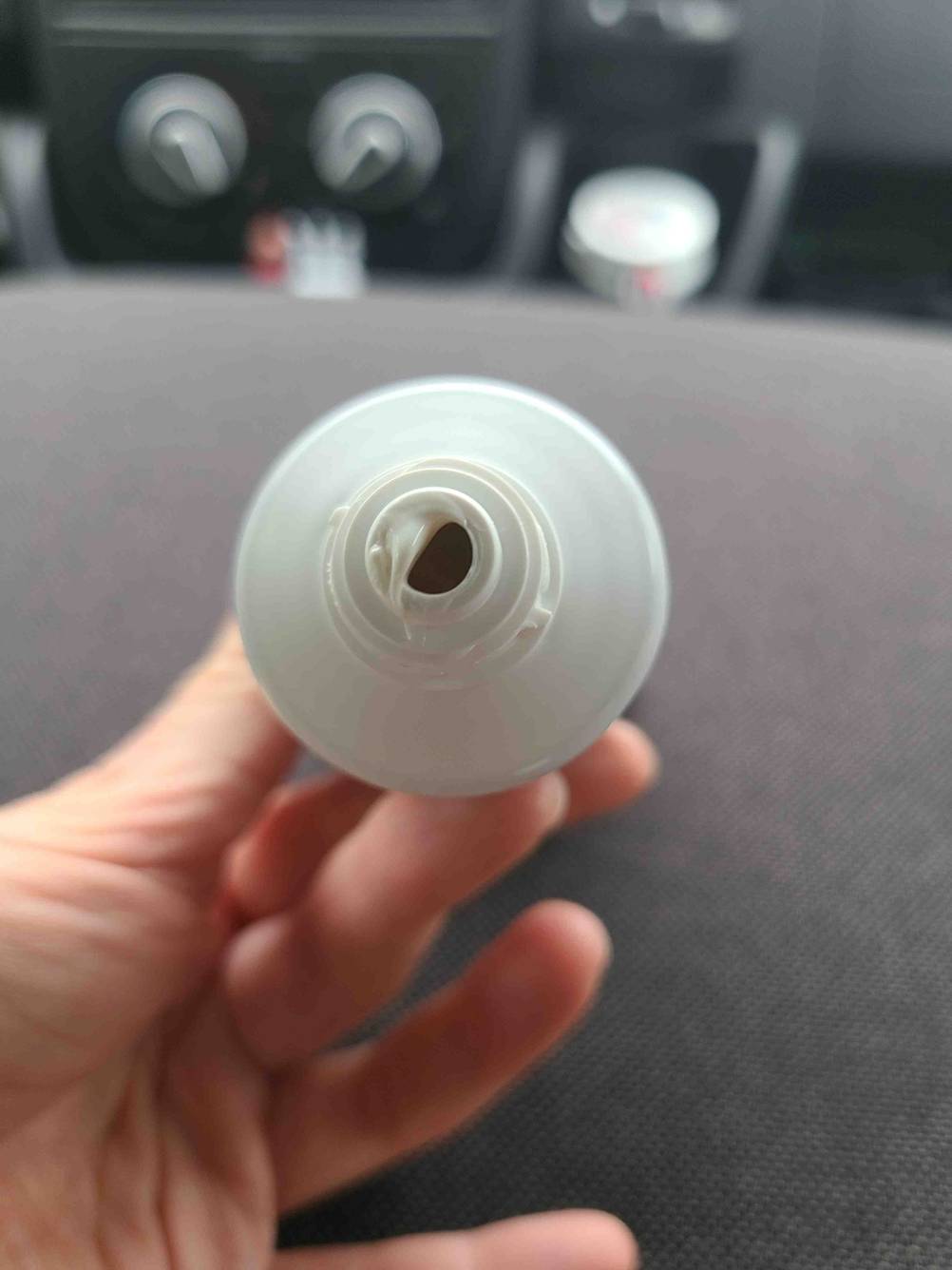 Eine Hand hält die geöffnete Tube der milden Zahnpasta im Test.
