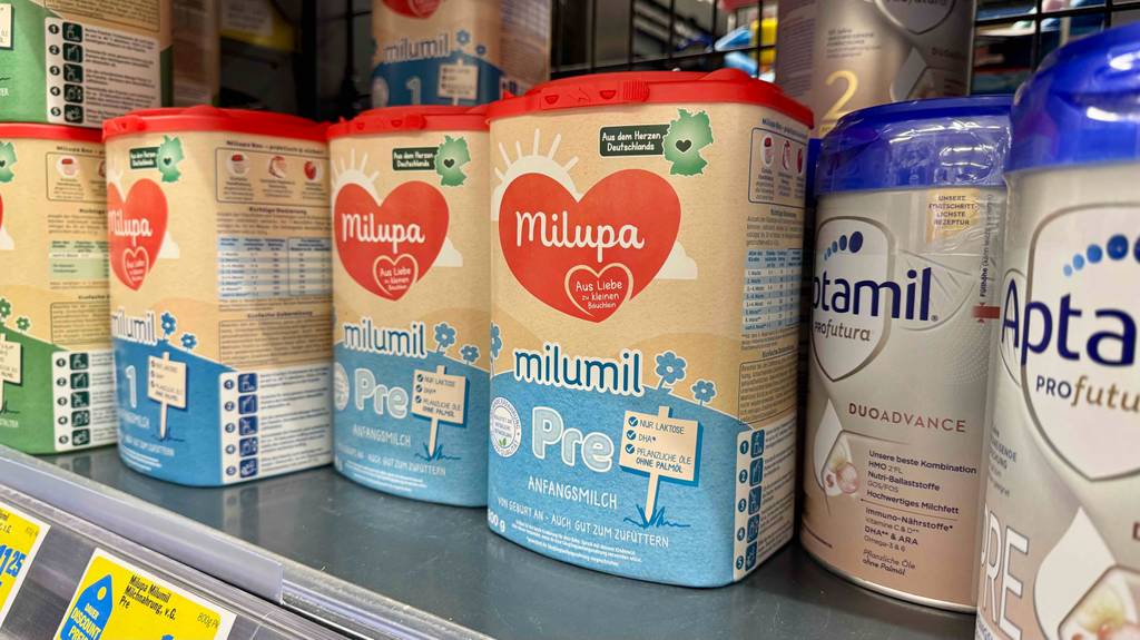Milupa-Babynahrung im Test: Mehrere Dosen unterschiedlicher Sorten stehen in einem Regal.