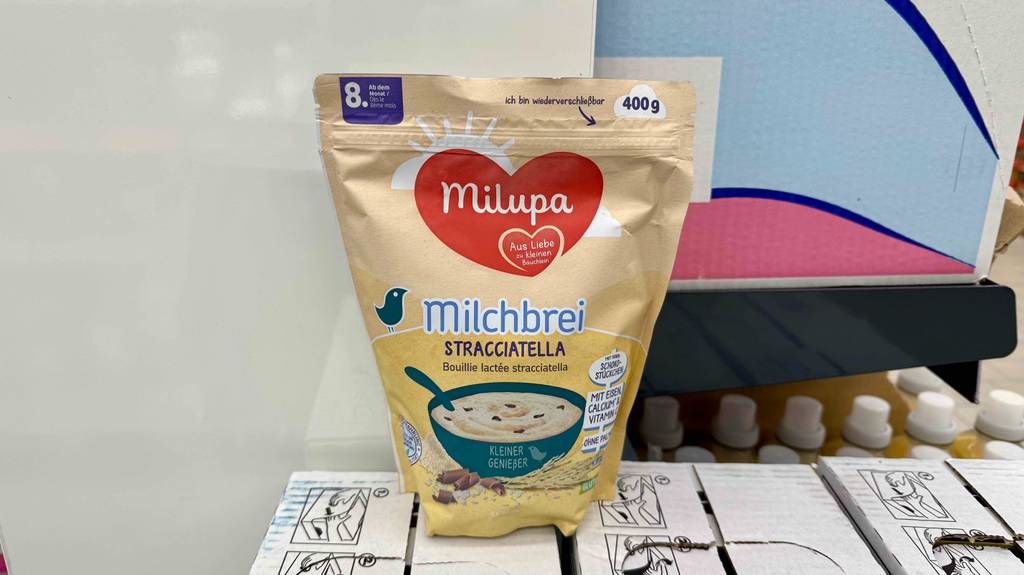 Getesteter Milchbrei in der 400-g-Tüte der Marke Milupa steht auf einem Karton im Geschäft.