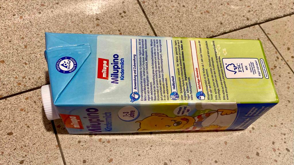 Im Test: Tetrapack Milupino Kindermilch mit Angaben zu Inhalt, Aufbewahrung und Hinweisen liegt auf Fliesen.