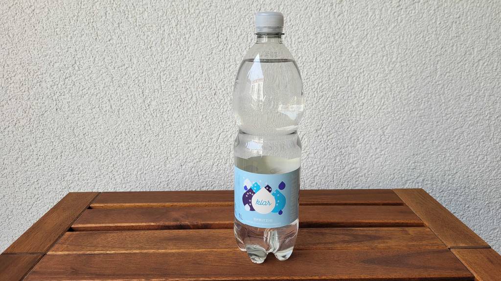 Eine getestete Mineralwasser-Flasche steht auf einem Holztisch. 