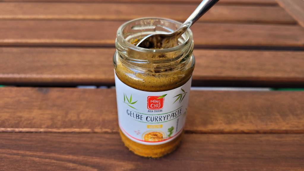 Würzige gelbe Currypaste Ming Chu im Glas.