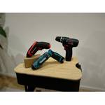 Drei verschiedene Mini-Akkuschrauber sind auf einem Rollwagen ausgestellt.