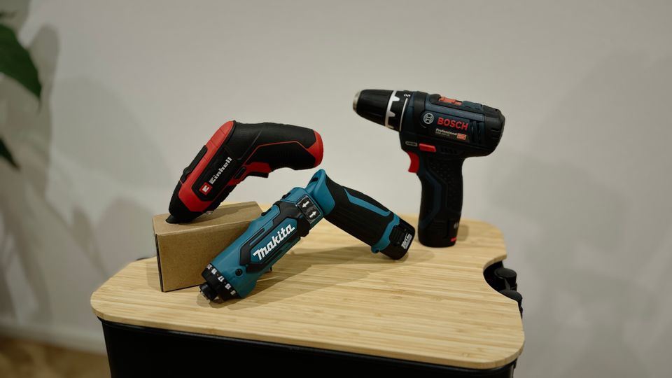 Drei verschiedene Mini-Akkuschrauber sind auf einem Rollwagen ausgestellt.