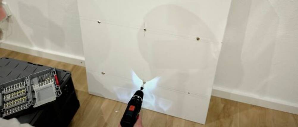 Mit dem Mini-Akkuschrauber von Bosch wird eine Schraube an einem Regal befestigt.