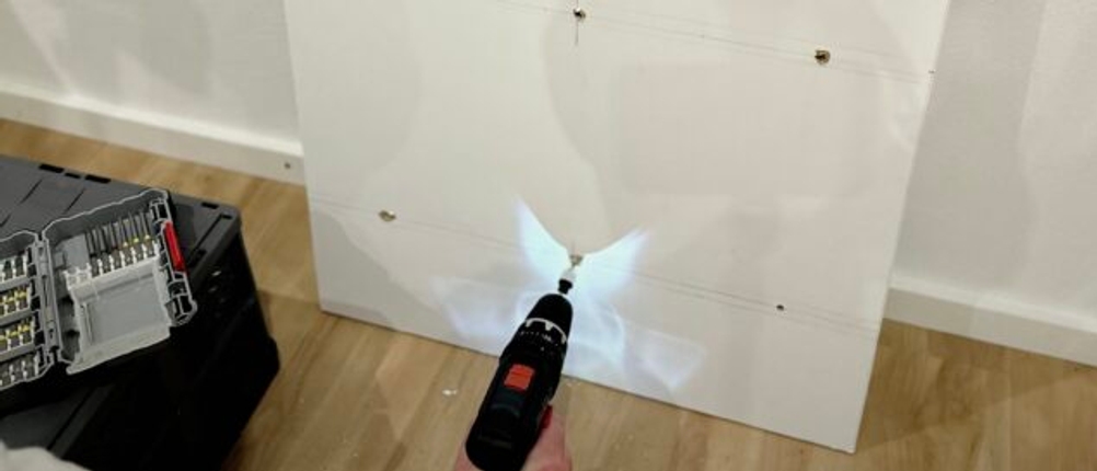 Mit dem Mini-Akkuschrauber von Bosch wird eine Schraube an einem Regal befestigt.