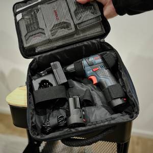 Der Mini-Akkuschrauber von Bosch wird mit einer Stofftragetasche hochgehalten.