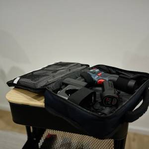 Der Mini-Akkuschrauber von Bosch liegt in einer geöffneten Stofftragetasche auf einem Rollwagen.