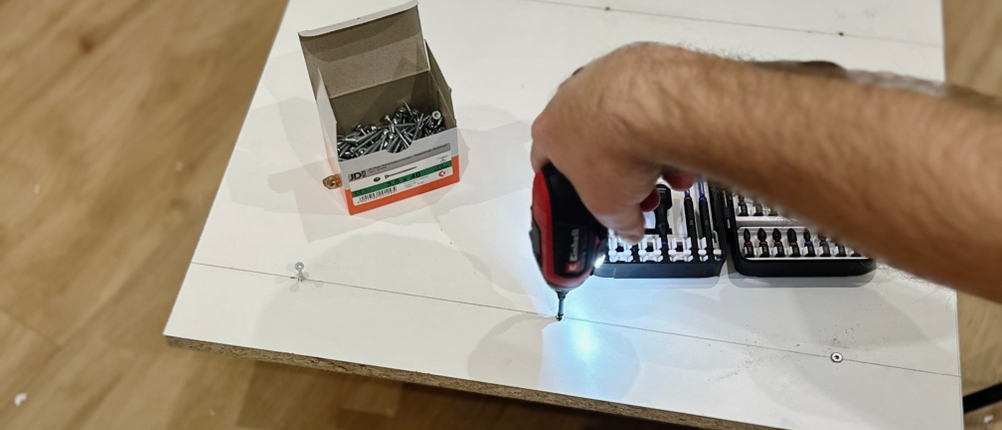 Mit dem Mini-Akkuschrauber von Einhell wird eine Schraube in eine Spanplatte geschraubt.