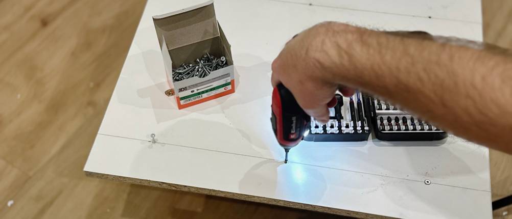 Mit dem Mini-Akkuschrauber von Einhell wird eine Schraube in eine Spanplatte geschraubt.