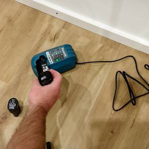 Der Akku des Makita-Mini-Akkuschraubers wird in die Ladestation gesteckt.