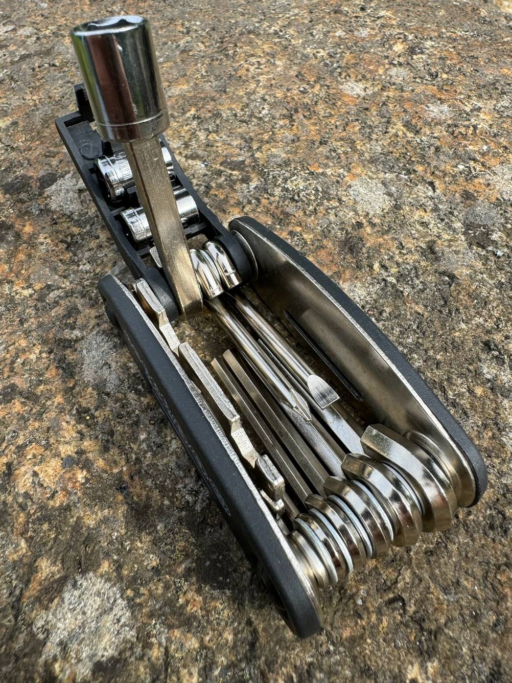 Getestet: Ein Mini-Multitool aufgefaltet auf einem Stein.