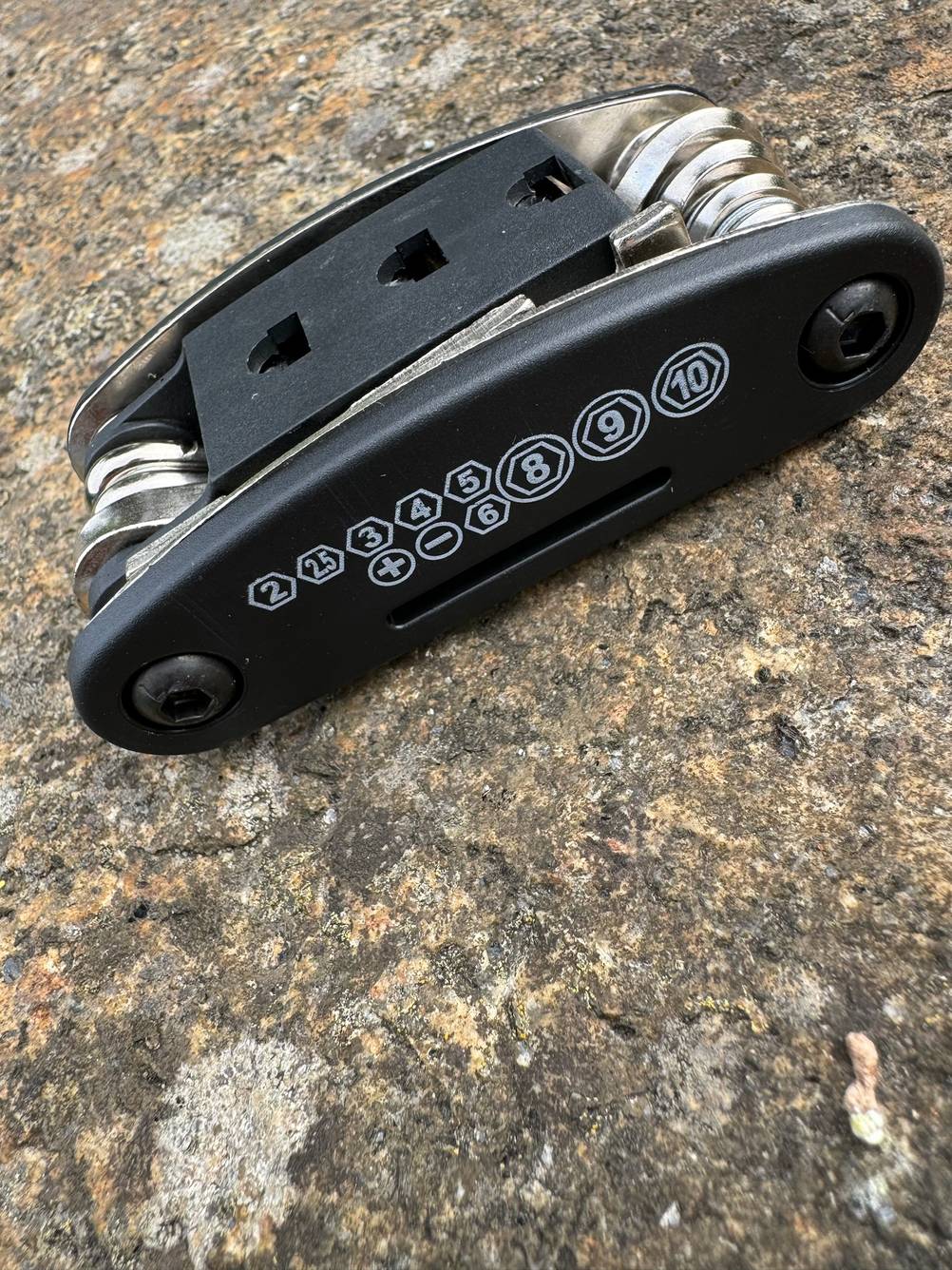 Mini-Multitool getestet: Ein Gerät von schräg seitlich auf einem Stein.