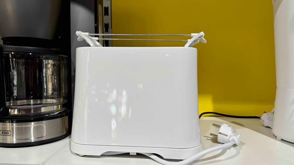 Der getestete Mini-Toaster in einem Verkaufsregal zwischen anderen Produkten mit Stormkabel.