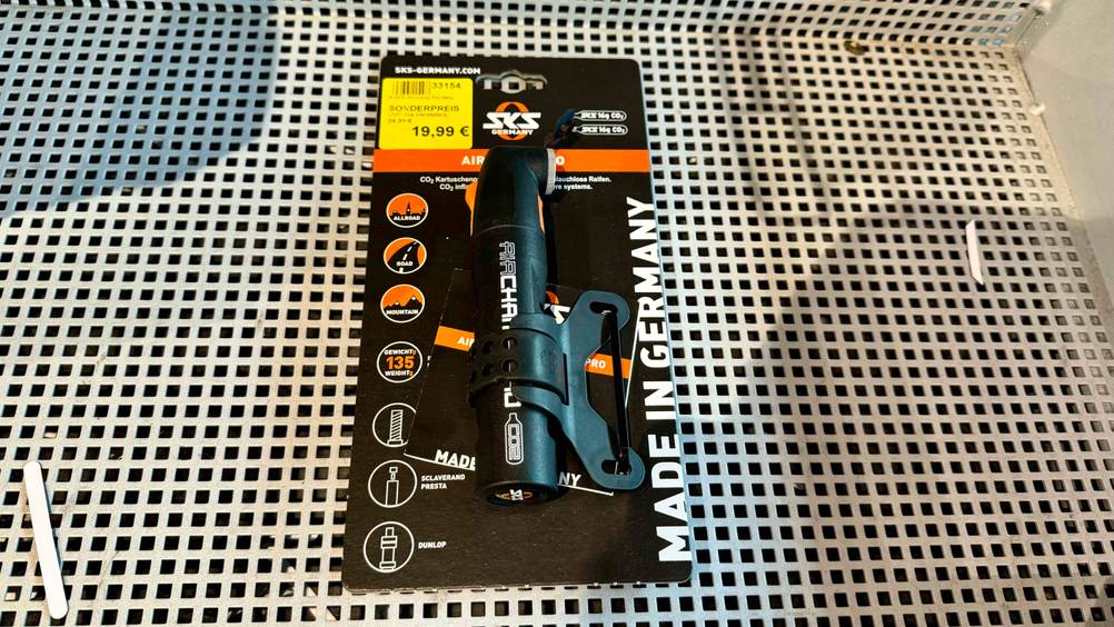 Minipumpe getestet: Ein Produkt von schräg oben in Originalverpackung mit Preisangabe auf einem weißen Lochblech.