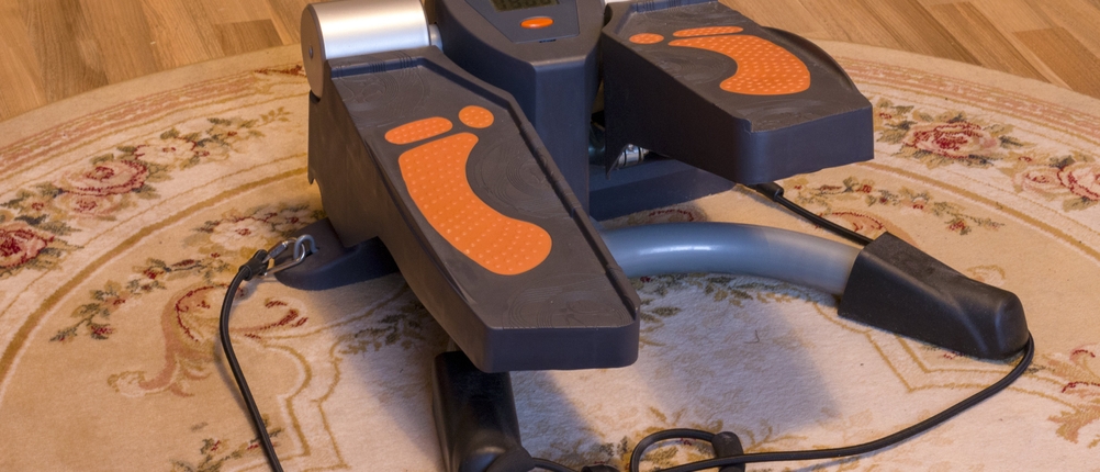 Mini-Stepper-Test: Ein Mini-Stepper mit Zugbändern auf einem runden Teppich. 