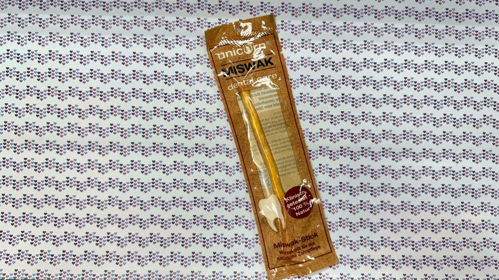 Ein getestetes Miswak auf einer Stofffläche liegend.