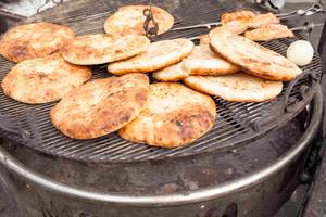Mehrere Fladenbrote auf einem Grillrost.
