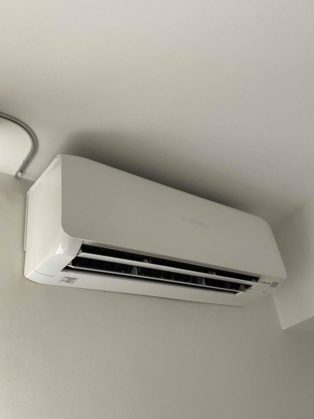 Eine Wandklimaanlage im Test hängt im Eck eines Zimmers.