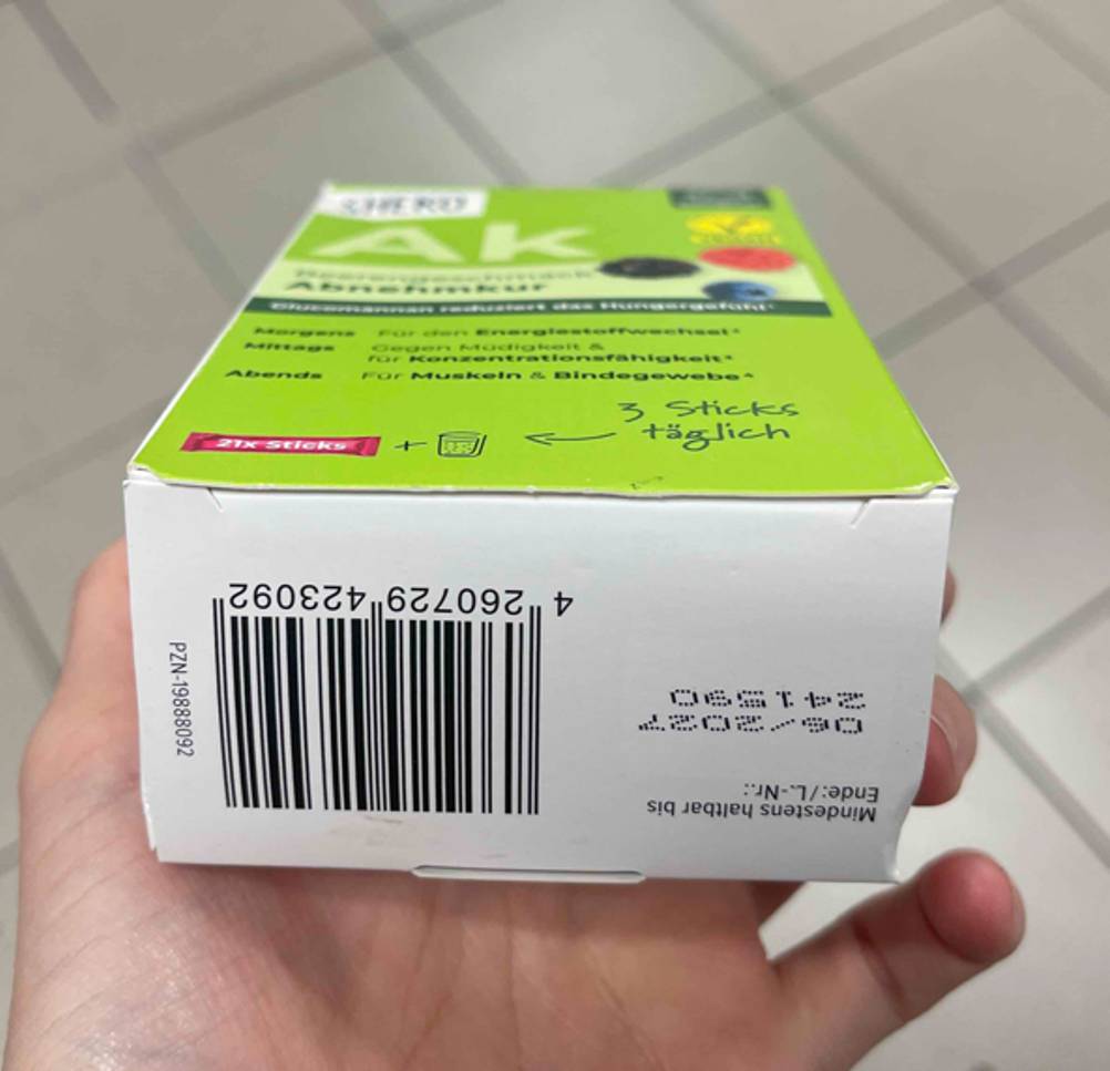 Nahaufnahme des Haltbarkeitsdatums auf dem weißen Boden der Verpackung mit dem Mittel zum Abnehmen im Test.