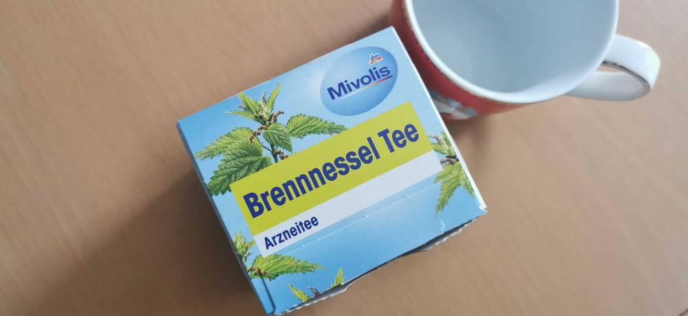 mivolis Brennnesseltee neben leerer Tasse