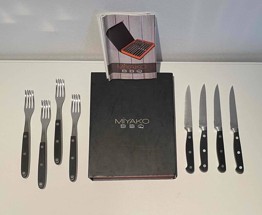 Im Test: Miyako Steakbesteck im Set für 4 Personen liegt links und rechts neben dem Aufbewahrungskoffer auf weißer Fläche.