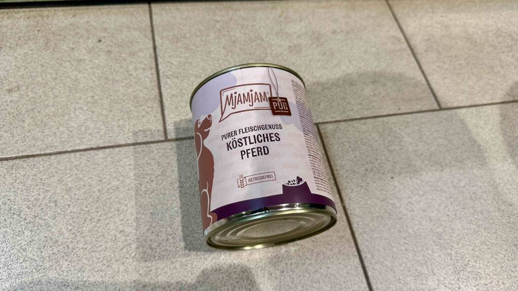 Eine Dose Hundefutter Pferd liegt zum testen auf einem Fliesenboden.