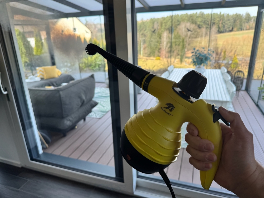 Der Mlmlant-Handgerät-Dampfreiniger wird von einer Hand gehalten, während er in die Luft dampft