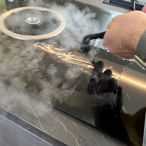 Der Mlmlant-Handgerät-Dampfreiniger beim Reinigen eines Herdes