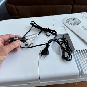 Eine Hand hält den 12V-Stromanschluss der Mobicool MQ40A fest.