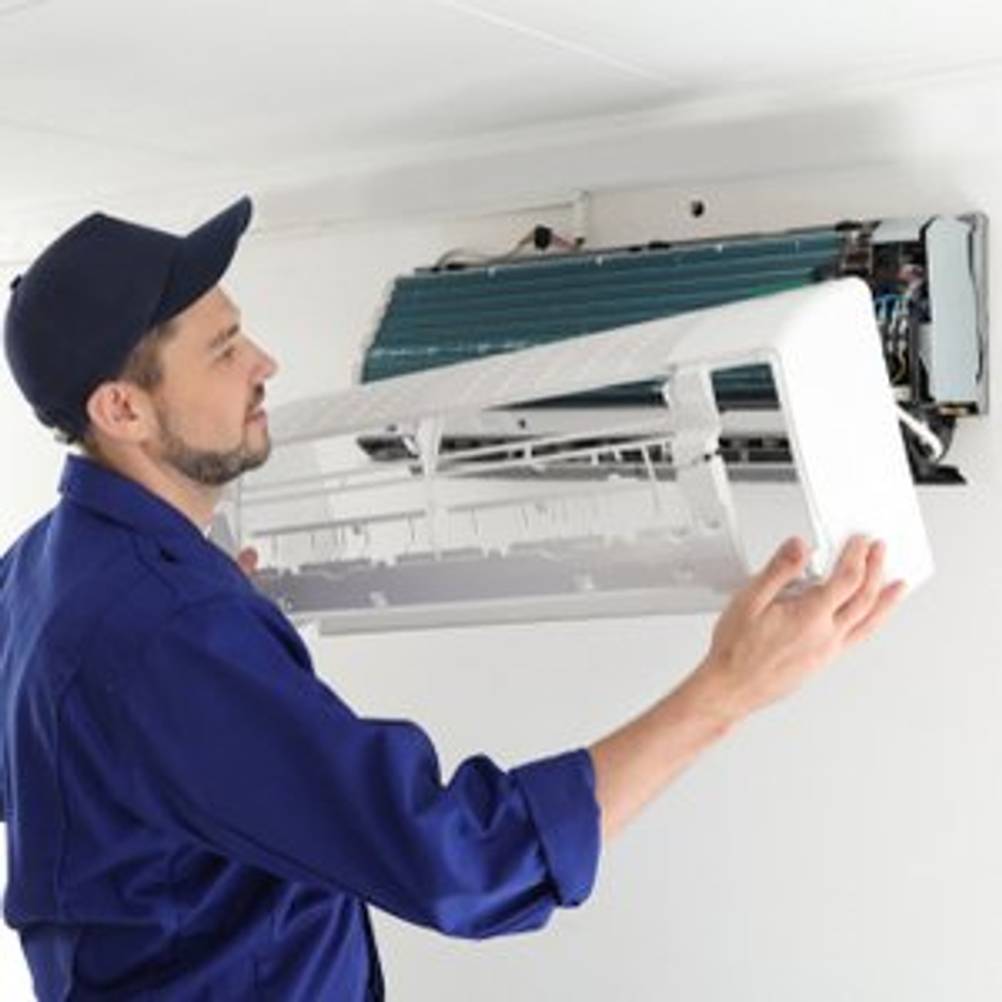 Techniker, der eine Klimaanlage in einer Wohnung montiert