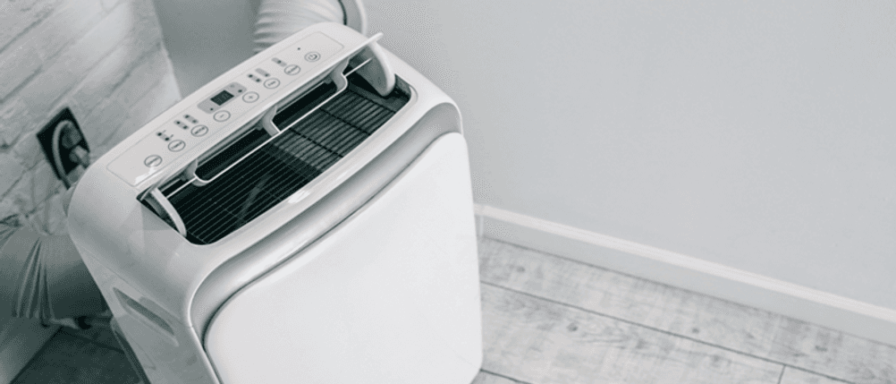 Mobile Split-Klimaanlage im Test: Ein Klimagerät steht auf dem Boden, der Abluftschlauch wird durch eine Wand geführt.