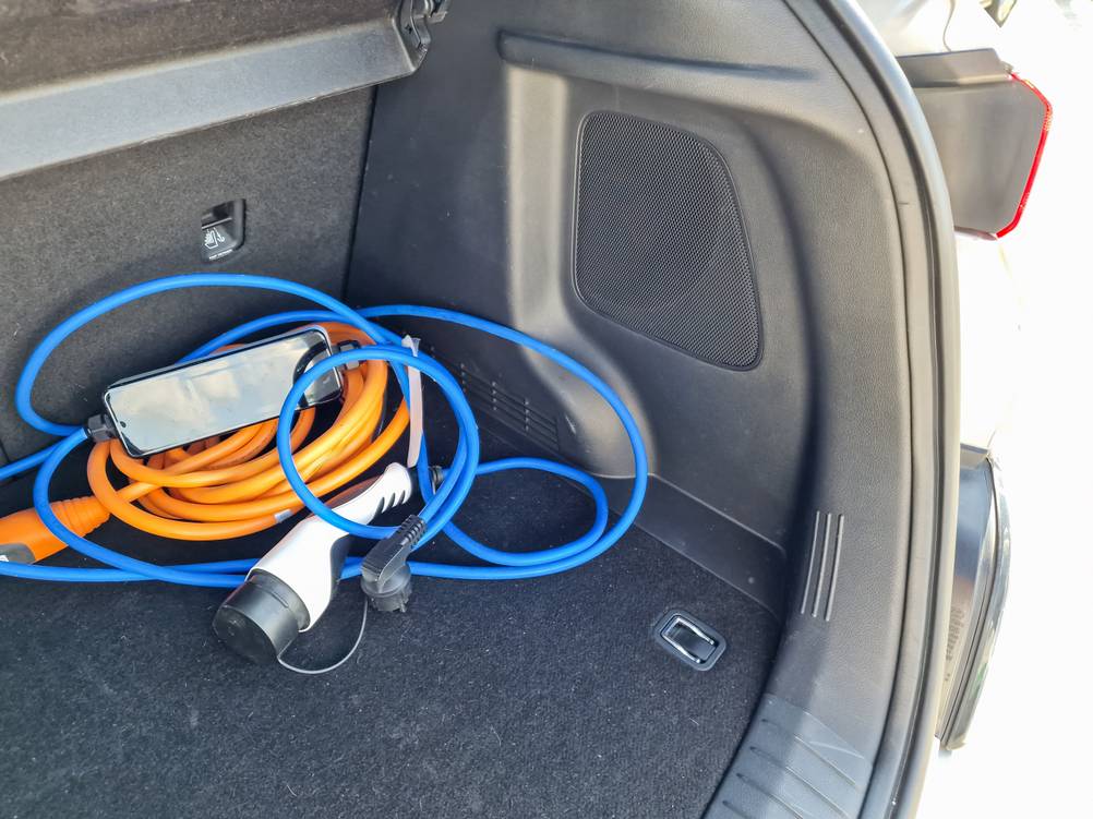 Mobile Wallbox im Test: Ein Ladegerät liegt in einem Kofferraum mit Schukostecker im Vordergrund.