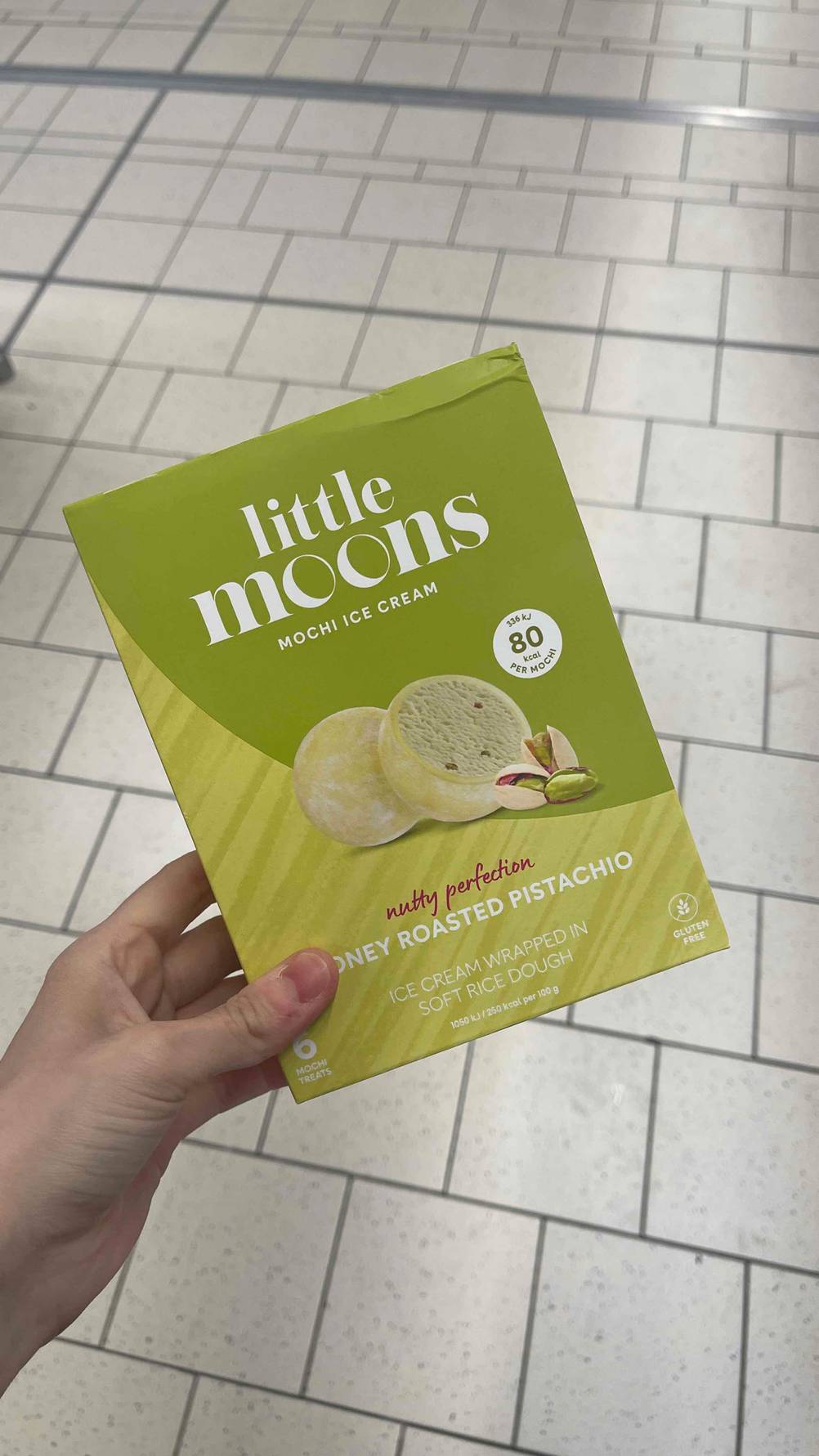 Die Vorderseite der Verpackung der Mochi im Test von einer Hand gehalten.