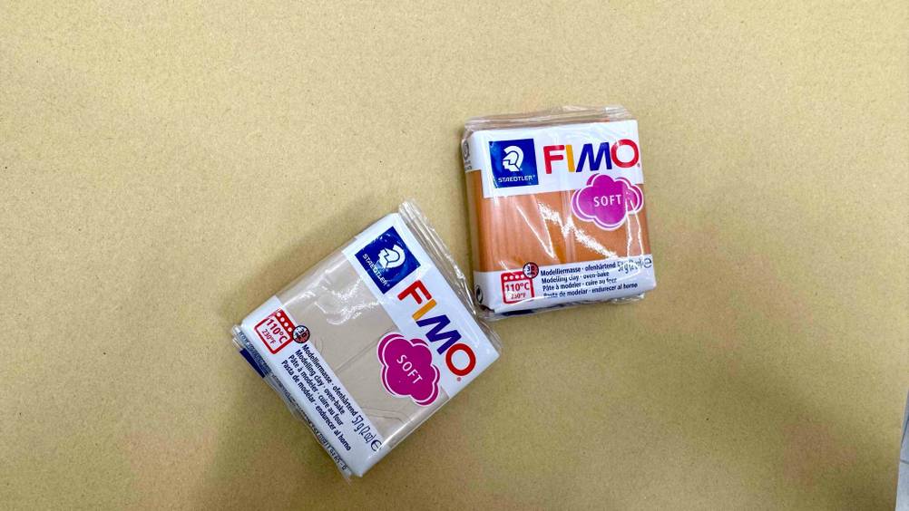 Getestet: Auf einer hellen Fläche befinden sich zwei Packungen Modelliermasse von oben.