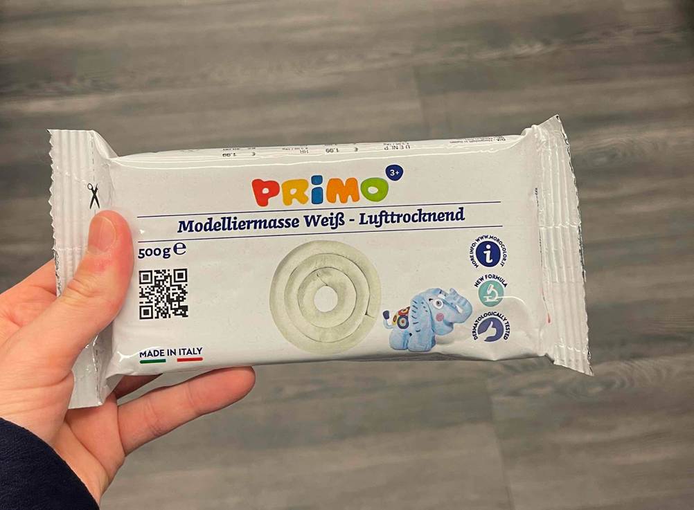 Eine Hand hält eine Packung der getesteten Modelliermasse.