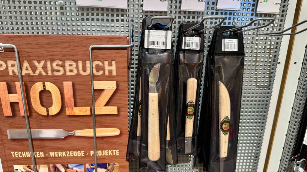 Schnitzmesser-Test: Unterschiedliche Schnitzmesser hängen an einem Werkzeugregal für Holz.