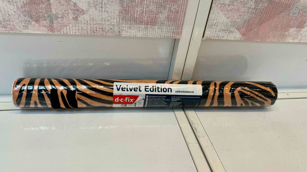 Möbelfolie getestet: Eine originalverpackte Rolle vor einer hellen Wand mit Fokus auf das Logo.