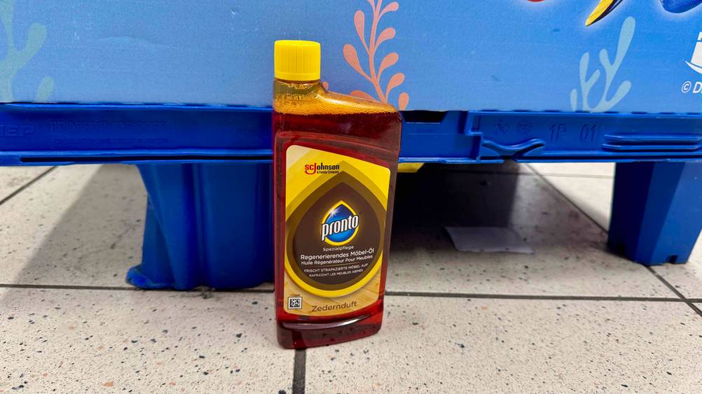 Getestet: Eine Flasche der Möbelpflege im Test vor einer blauen Palette auf dem Boden.