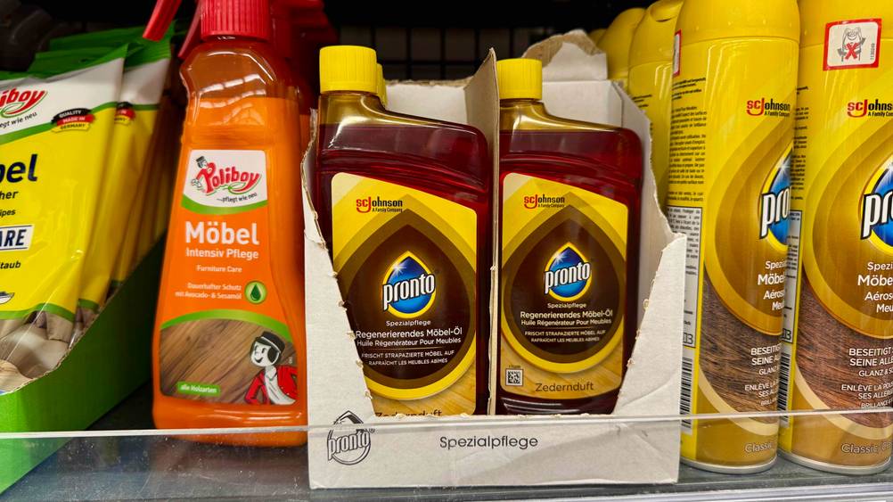 Mehrere Flaschen der getesteten Möbelpflege in einem Verkaufsregal neben anderen Produkten.