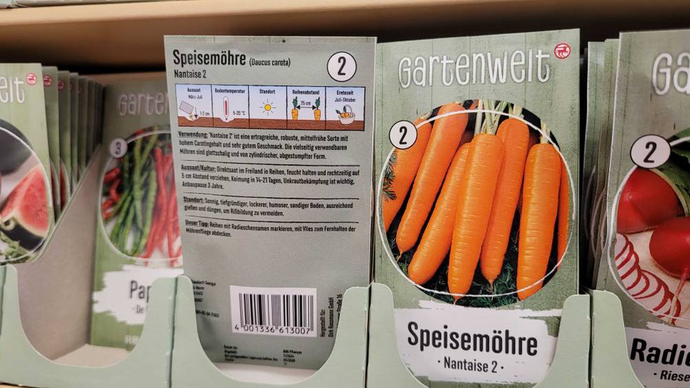 Mehrere Packungen der Möhren-Samen im Test in einem Verkaufsregal neben anderen Produkten.