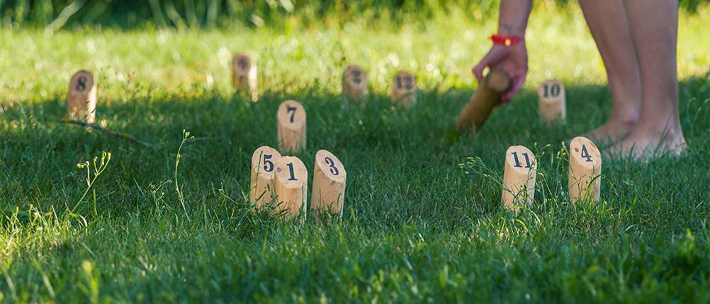 Mölkky im Test: Ein Spieler der sein Wurfholz aufhebt.