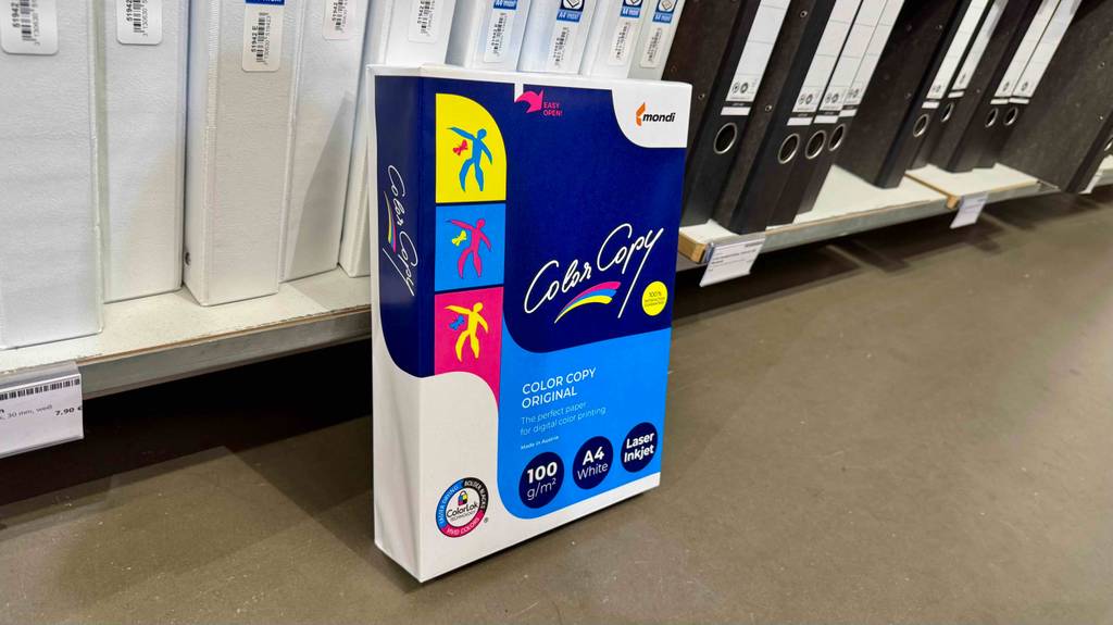 Ein Pack Kopierpapier A4 steht zum testen vor einem Ordnerregal auf dem Boden.