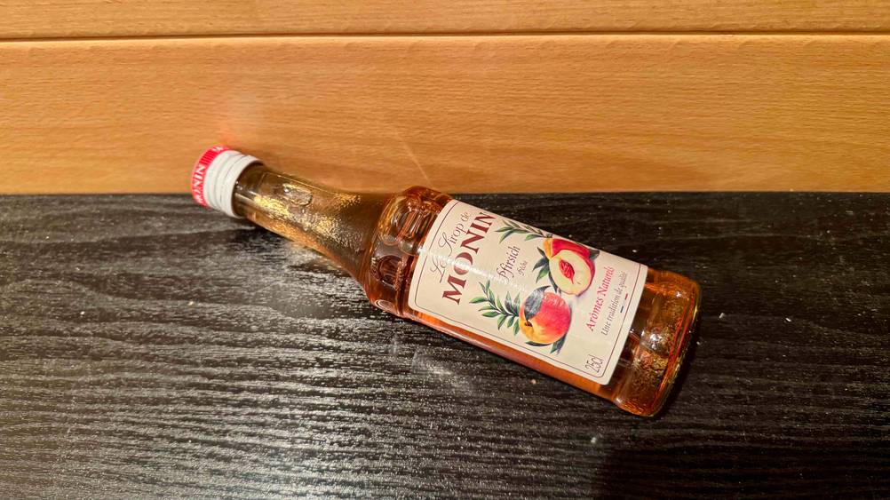 Monin-Sirup im Test: Eine Flasche horizontal auf einem Holzuntergrund.